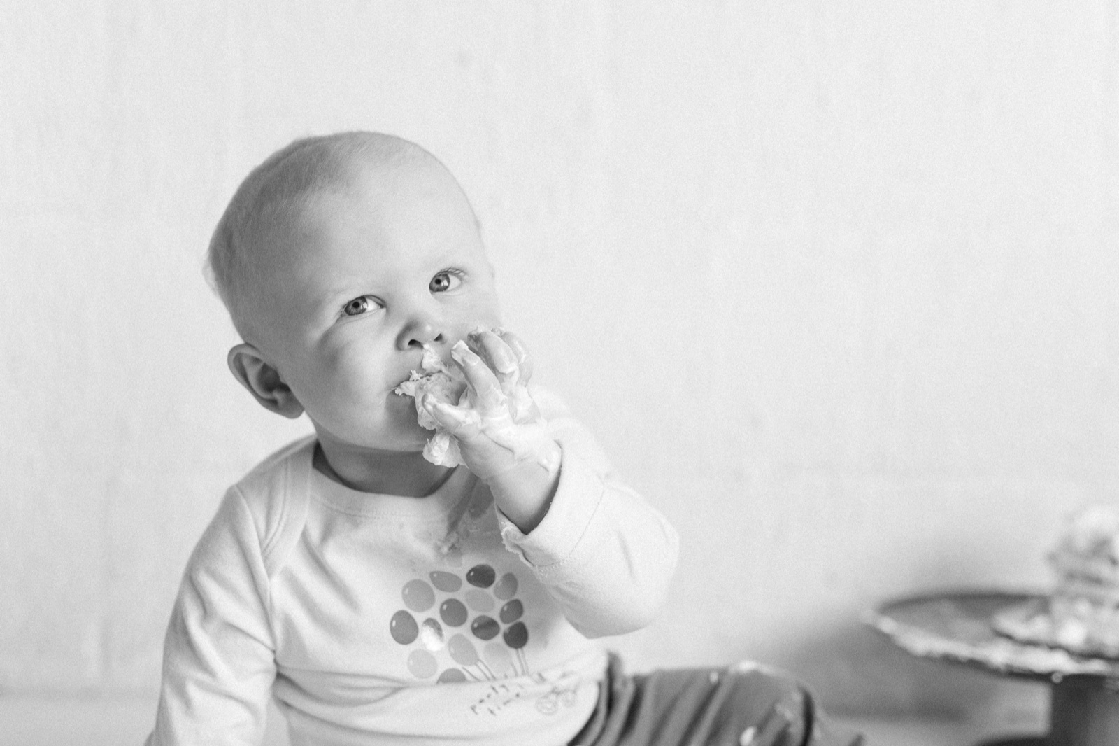 A baby exploring solid food in a highchair